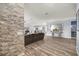 Open-concept living room with wood-look flooring, stone accent wall, and neutral decor at 1107 Se 49Th Ave, Ocala, FL 34471