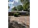 Home backyard with a screened-in porch, green bushes, and a view of the back exterior at 1325 Nw 73Rd Ter, Ocala, FL 34482