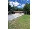 Sprawling single story home featuring multiple garage doors surrounded by mature trees and landscaping at 1325 Nw 73Rd Ter, Ocala, FL 34482