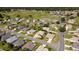 Scenic aerial view of a vibrant residential community nestled alongside a lush green golf course, showcasing well-maintained homes at 14004 Se 94Th Ave, Summerfield, FL 34491
