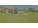 This backyard features lush grass, mature landscaping, and a quaint white picket fence for privacy at 14004 Se 94Th Ave, Summerfield, FL 34491