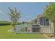 Spacious backyard featuring a lush lawn, white picket fence, and a screen enclosed porch at 14004 Se 94Th Ave, Summerfield, FL 34491