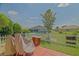 A cozy backyard with a stone table, seating, and lush lawn enclosed by a white picket fence at 14004 Se 94Th Ave, Summerfield, FL 34491