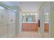 Well-lit bathroom with a glass shower enclosure, double vanity, and tiled flooring at 14004 Se 94Th Ave, Summerfield, FL 34491