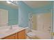 Cozy bathroom featuring a bathtub with shower, oak vanity and blue walls at 14004 Se 94Th Ave, Summerfield, FL 34491