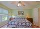 Comfortable bedroom with decorative quilt, ceiling fan, and natural light from the window at 14004 Se 94Th Ave, Summerfield, FL 34491