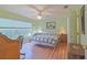 Comfortable bedroom with wood floors, a ceiling fan, and a large window with a view at 14004 Se 94Th Ave, Summerfield, FL 34491