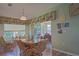 Charming dining area featuring wood floors, seating for six, decor, and a view of the screened patio at 14004 Se 94Th Ave, Summerfield, FL 34491