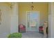 Close up of the entrance to this home with chairs, statue and decorative glass door at 14004 Se 94Th Ave, Summerfield, FL 34491