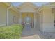 Inviting covered front entrance with ornate door, flanked by decorative art and lush greenery at 14004 Se 94Th Ave, Summerfield, FL 34491