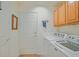 Functional laundry area with washer, dryer, cabinet storage, and door to exterior at 14004 Se 94Th Ave, Summerfield, FL 34491