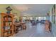 Spacious living room with wood flooring, chandelier, desk, bookcases, and comfortable seating at 14004 Se 94Th Ave, Summerfield, FL 34491