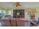 Bright living room with leather recliners, entertainment center, and ceiling fan at 14004 Se 94Th Ave, Summerfield, FL 34491