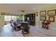 Large living room featuring cozy leather furniture, TV, and tropical ceiling fan at 14004 Se 94Th Ave, Summerfield, FL 34491
