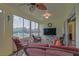 Spacious screened patio features comfortable seating, a television, and a ceiling fan, great for relaxing outdoors at 14004 Se 94Th Ave, Summerfield, FL 34491