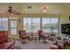 Inviting screened patio with tile flooring, comfortable seating, and a ceiling fan for relaxed outdoor living at 14004 Se 94Th Ave, Summerfield, FL 34491