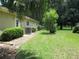 Spacious backyard with lush green grass, mature trees, and AC unit at 14561 Sw 112Th Cir, Dunnellon, FL 34432