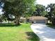 Charming single story home featuring a lush green lawn, mature trees and a two car garage at 14561 Sw 112Th Cir, Dunnellon, FL 34432