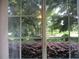 Window view featuring a green lawn, shrubbery and trees at 14561 Sw 112Th Cir, Dunnellon, FL 34432