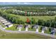 This aerial shot highlights a neighborhood home situated near trees and an open field with scenic surroundings at 160 Hickory Course Loop, Ocala, FL 34472