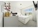 A cozy bedroom featuring a unique white accent wall, a chandelier, and a bright window view at 160 Hickory Course Loop, Ocala, FL 34472