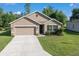 Charming single-story home featuring a well-manicured lawn, attached garage, and neutral-toned exterior at 160 Hickory Course Loop, Ocala, FL 34472