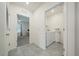 An elegant hallway with tile flooring leading to a bedroom and a convenient laundry room at 160 Hickory Course Loop, Ocala, FL 34472