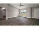 Spacious living room with hardwood floors and a large window overlooking the front yard at 20 Emerald Trl, Ocala, FL 34472