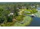 Serene aerial shot of lakefront properties featuring a dock, water lilies, surrounded by lush greenery and natural beauty at 23797 Ne 189Th St, Fort Mc Coy, FL 32134