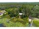 Aerial view of a lakefront property with a dock, featuring beautiful water lily pads, surrounded by a dense forest at 23797 Ne 189Th St, Fort Mc Coy, FL 32134