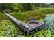 Picturesque dock with built-in seating, creating a perfect spot to enjoy the tranquil, lily-covered waterfront view at 23797 Ne 189Th St, Fort Mc Coy, FL 32134