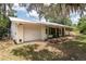 Single-story home with attached garage and green shutters, nestled on a shady lot at 23797 Ne 189Th St, Fort Mc Coy, FL 32134