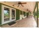 Relaxing covered porch with tiled flooring and multiple ceiling fans at 23797 Ne 189Th St, Fort Mc Coy, FL 32134