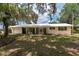 Charming single-story home with a lush lawn, bright exterior, and welcoming double doors at 23797 Ne 189Th St, Fort Mc Coy, FL 32134