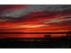 Breathtaking sunset over lake with vibrant colors and silhouettes of trees and a boat at 23797 Ne 189Th St, Fort Mc Coy, FL 32134