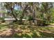 Exterior view of home and shed with carport, nestled under mature trees and moss-draped branches at 23797 Ne 189Th St, Fort Mc Coy, FL 32134