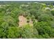 Expansive aerial view showcasing lush greenery and a cleared area with a fire pit in the distance at 2580 Se 157Th Lane Rd, Summerfield, FL 34491