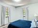 Bedroom with a plush blue bed, hardwood floors, and white curtains at 2580 Se 157Th Lane Rd, Summerfield, FL 34491