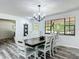 Elegant dining room with hardwood floors, a modern chandelier, and a view of the outdoors at 2580 Se 157Th Lane Rd, Summerfield, FL 34491