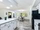Open concept kitchen and dining room with hardwood floors, white cabinets, quartz countertops, and bright natural light at 2580 Se 157Th Lane Rd, Summerfield, FL 34491
