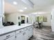 Open concept kitchen and dining room with hardwood floors, white cabinets, quartz countertops, and bright natural light at 2580 Se 157Th Lane Rd, Summerfield, FL 34491