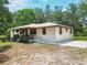 Inviting single-story home with a cozy front porch and ramp, set on a well-maintained grassy lot at 2580 Se 157Th Lane Rd, Summerfield, FL 34491
