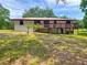 Charming home featuring a wooden deck and classic ranch-style architecture, nestled in a lush yard at 2580 Se 157Th Lane Rd, Summerfield, FL 34491
