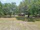 Sprawling ranch-style home with mature trees, a wooden deck, and a peaceful, shaded yard at 2580 Se 157Th Lane Rd, Summerfield, FL 34491