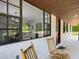 Cozy front porch featuring rocking chairs and large windows offering a glimpse into the dining and living spaces at 2580 Se 157Th Lane Rd, Summerfield, FL 34491