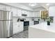 Well-lit kitchen featuring stainless steel appliances, white cabinets, a view to the window, and quartz countertops at 2580 Se 157Th Lane Rd, Summerfield, FL 34491
