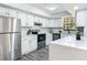 Well-lit kitchen featuring stainless steel appliances, white cabinets, a view to the window, and quartz countertops at 2580 Se 157Th Lane Rd, Summerfield, FL 34491