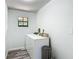 Bright laundry room with modern washer, dryer, natural light and sleek, gray flooring at 2580 Se 157Th Lane Rd, Summerfield, FL 34491