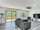 Spacious living room features hardwood floors, a ceiling fan, sliding glass doors to the deck, and ample natural light at 2580 Se 157Th Lane Rd, Summerfield, FL 34491