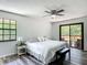 Main bedroom with deck access, ceiling fan and wood-look flooring at 2580 Se 157Th Lane Rd, Summerfield, FL 34491